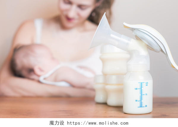 褐色木质桌子母亲拿吸奶器母乳喂养刚出生的婴儿